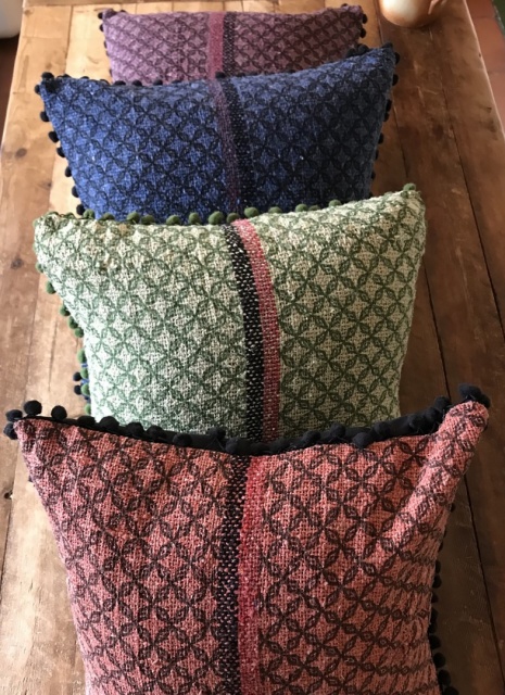Square, colourful heritage fabric cushion with pom pom fringing in 4 colour tones