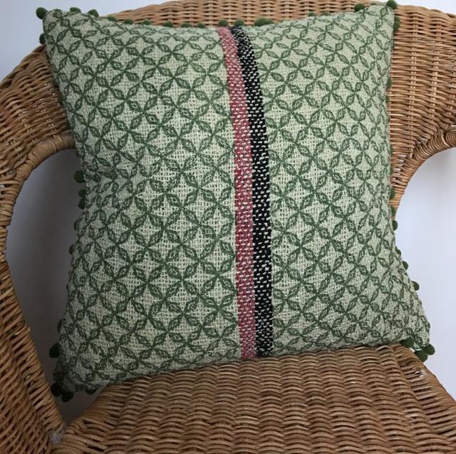 Square, colourful heritage fabric cushion with pom pom fringing in 4 colour tones