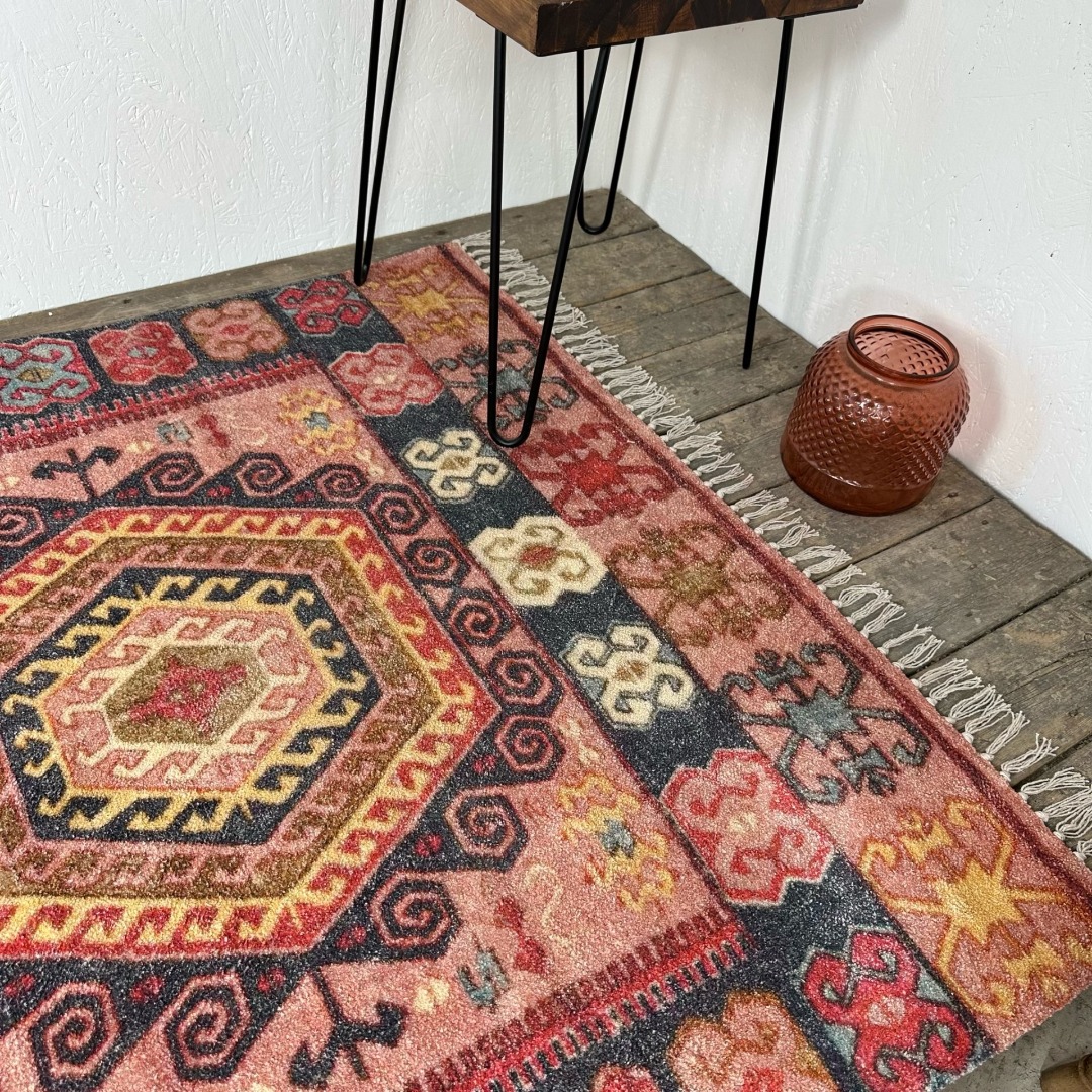 Geometric patterned rug in pink shades, tinted with blues and gold. 100% cotton 120cm x 180cm